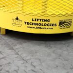 Crane hoisting material basket. Bottom view